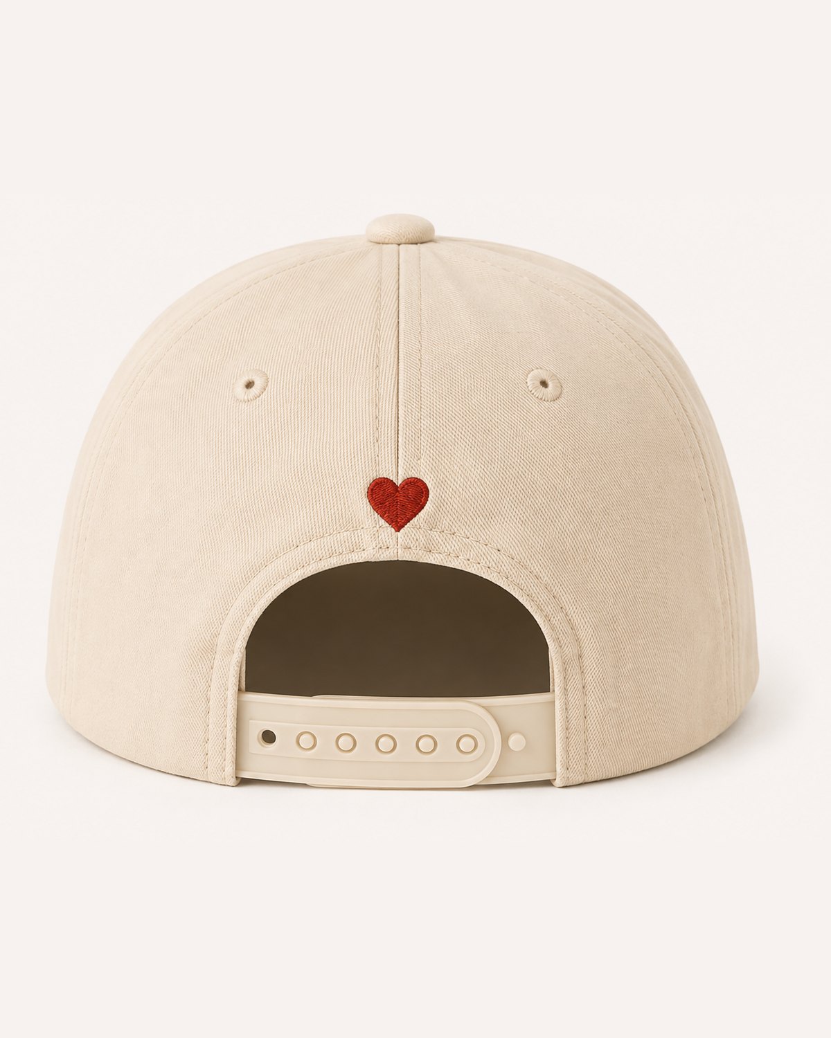 The back of the cream cap: the snapback and a small red heart.