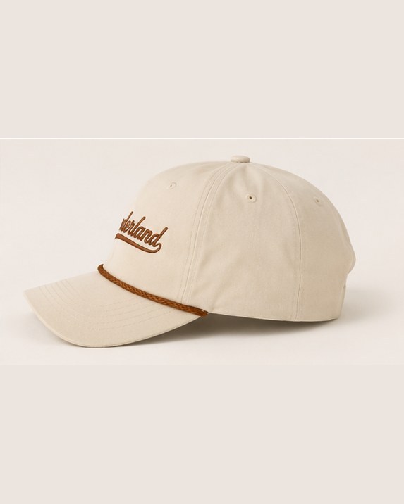 The cream rope cap from the side, the braid across the front panels.