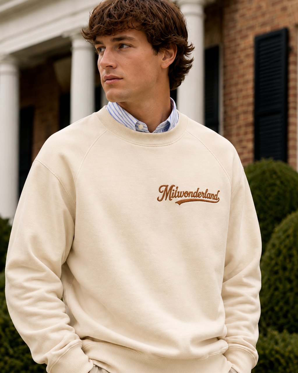 The bone flagship crewneck worn, the Milwonderland script in tawny on the chest.