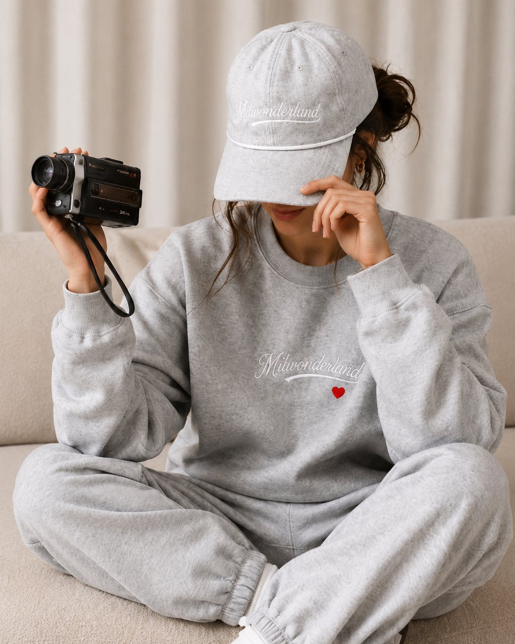 The grey heather flagship crewneck worn, script and heart on the chest.